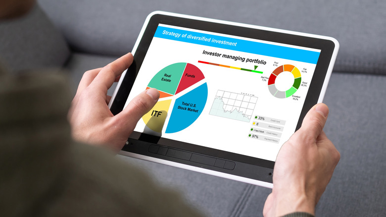 Man holds tablet showing colorful pie chart breakdown of stock portfolio