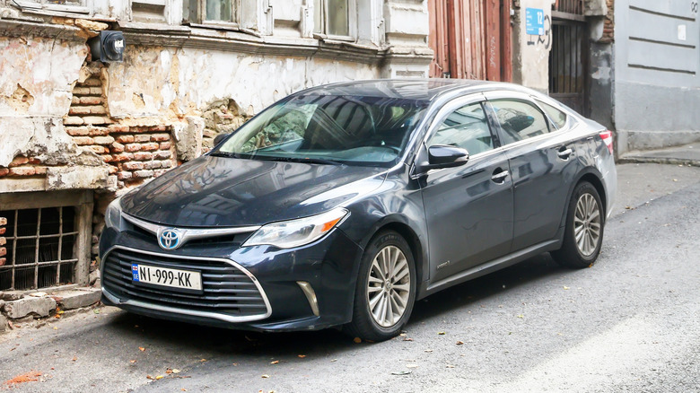 A black Toyota Avalon parked on a city street.