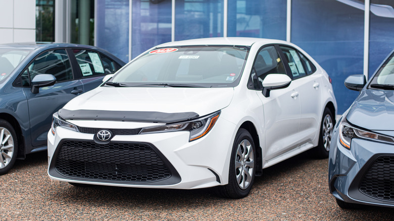 A white Toyota Corolla parked at a dealership.