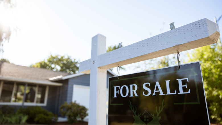 House with a for sale sign in front yard