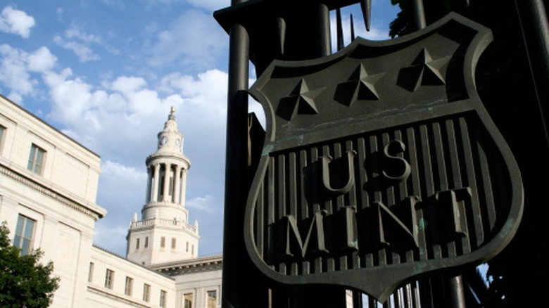 The U.S. Mint building gate with a building behind it in Denver, Colorado.