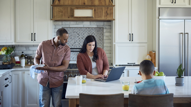 young family budgeting on a laptop in their kitchen