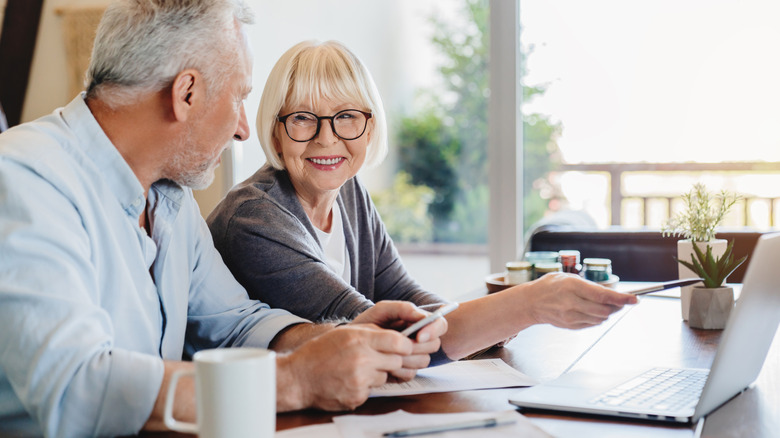Senior couple going over budget with computer and phone