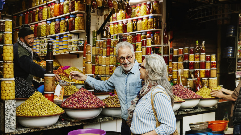 Senior couple trying food in foreign country.