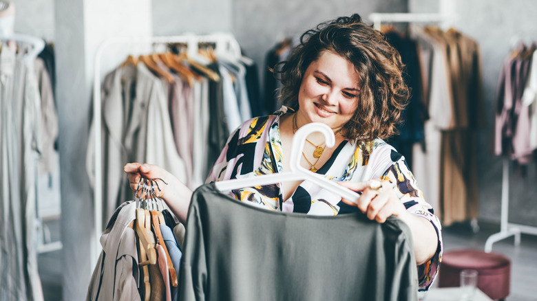 A woman choosing a dress in the store.