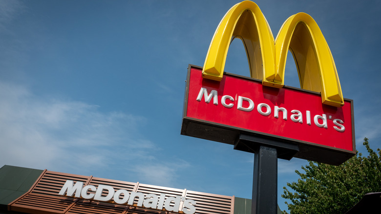 McDonald's sign outside of restaurant against blue sky