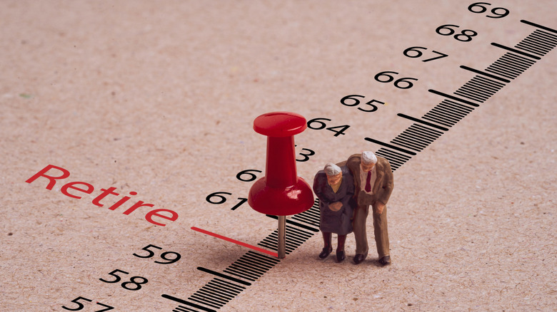 Couple choosing an age to retire from an age thermometer