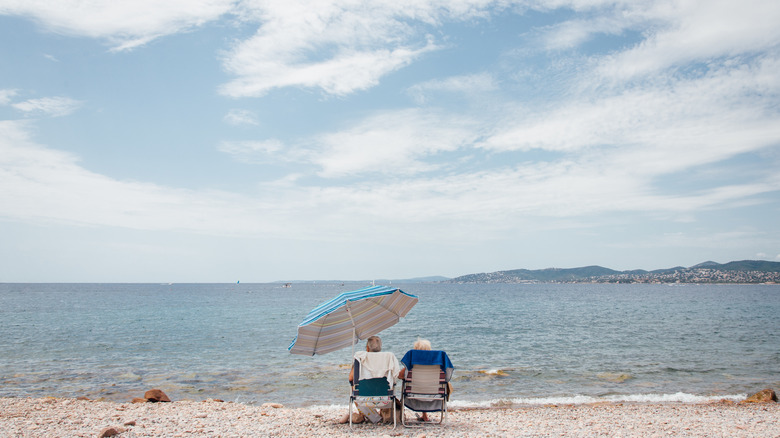 A couple sitting on chairs at the beach