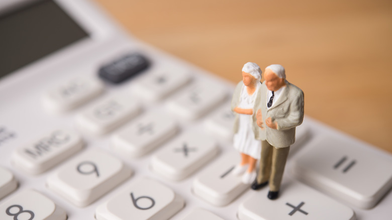 Miniature of older couple on a calculator