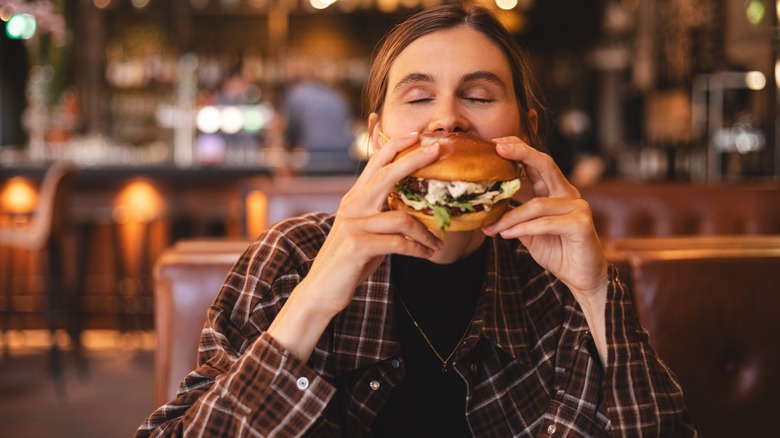 Woman in restaurant having a burger