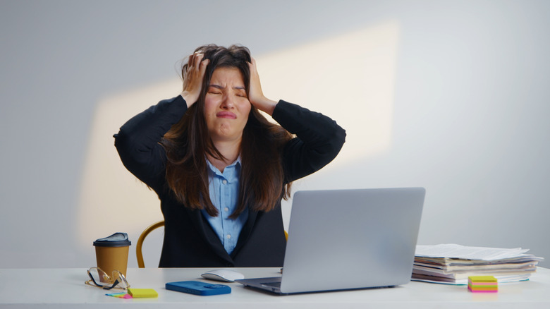Stressed woman worker with a laptop