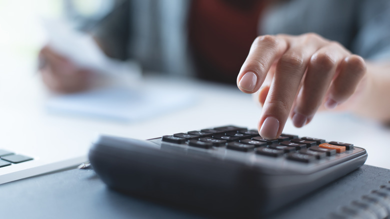 Person's hand using a calculator.