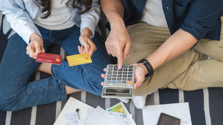 Stressed couple counting expenses on calculator