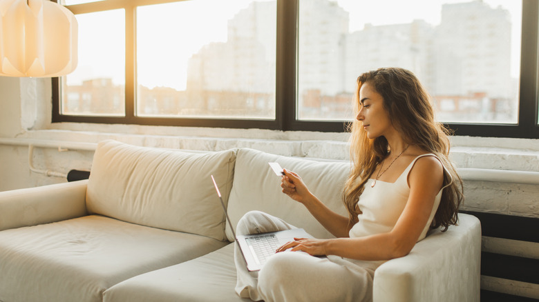 a woman uses her card to make an online purchase