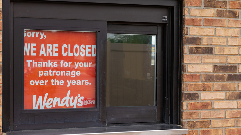 A closure sign in the drive through window of a Wendy's location.