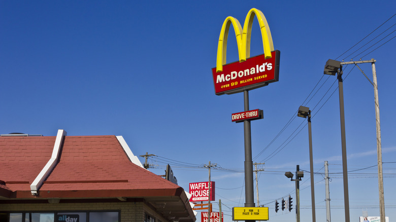 McDonald's sign outside of restaurant against blue sky