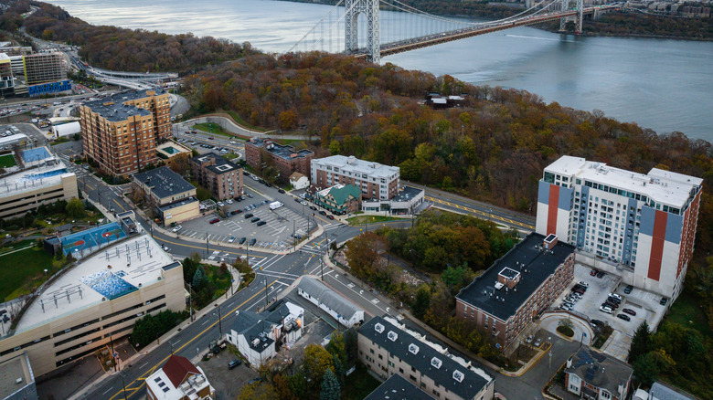An aerial view of modern buildings on a bank of a river in Fort Lee, New Jersey at sunset
