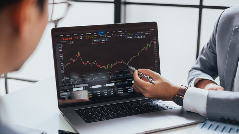 People looking at a price chart on a computer screen
