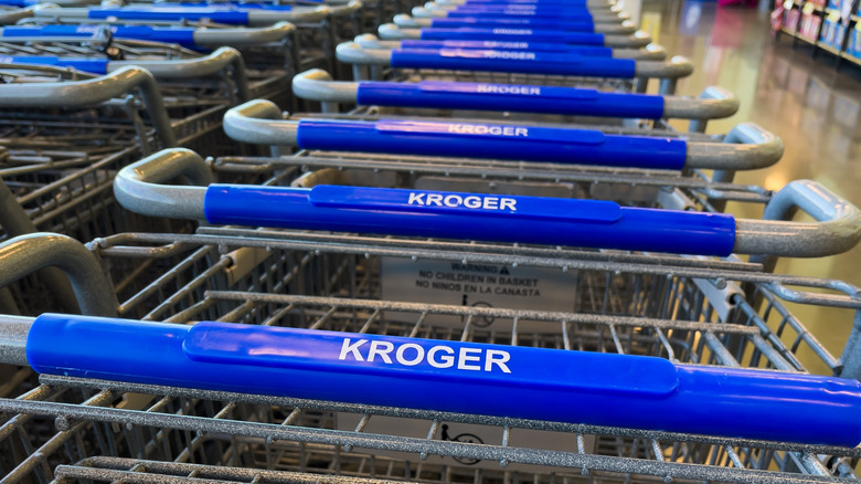 Shopping carts lined up with Kroger name on handle
