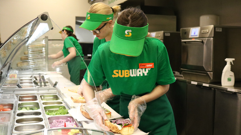 Employees making sandwiches at a Subway restaurant