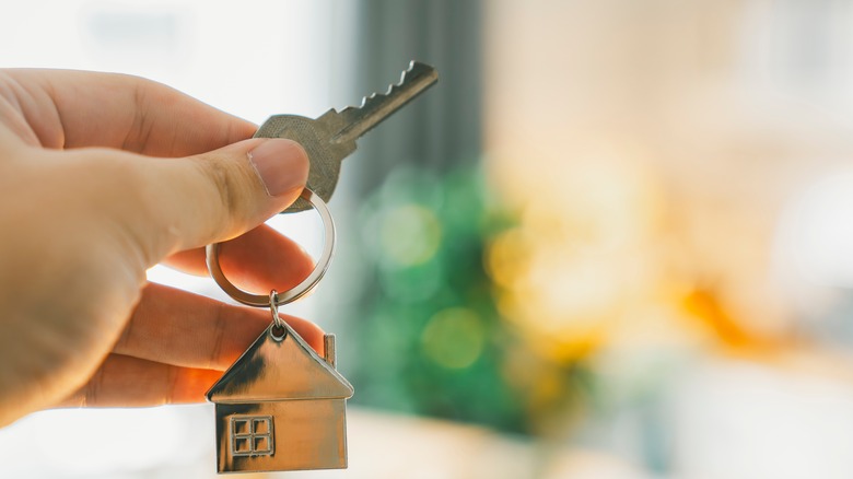 House model and key in home insurance broker agent 's hand