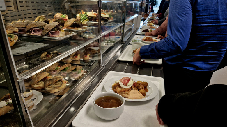 Line of people with trays in a cafeteria