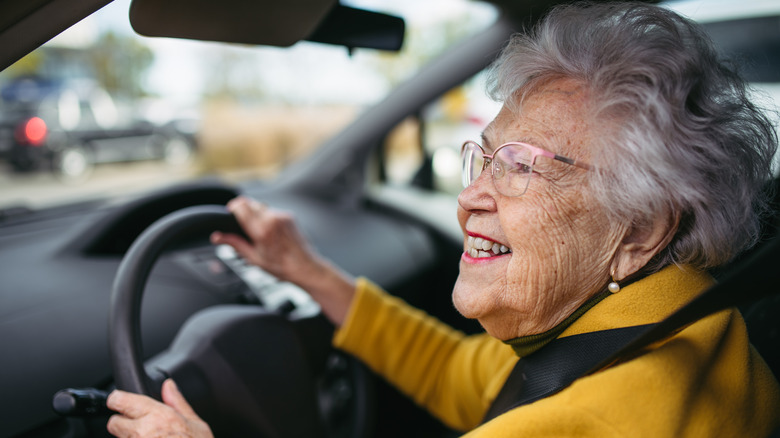 A senior woman driving car alone, enjoying the car ride