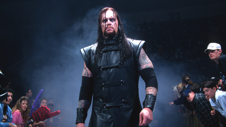 The Undertaker in a black outfit entering the WWE wresting ring