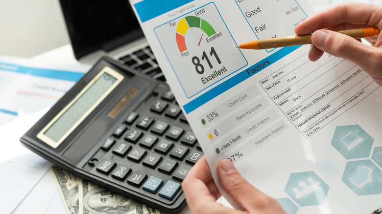 Hands holding a print out of a person's credit score