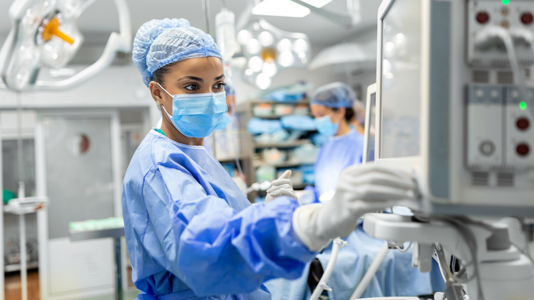 black female anesthesiologist adjusts equipment