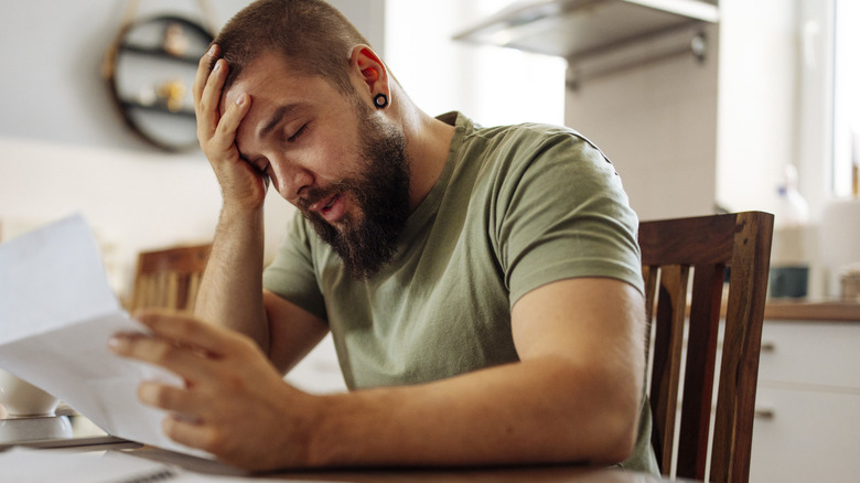 A stressed out young man paying bills