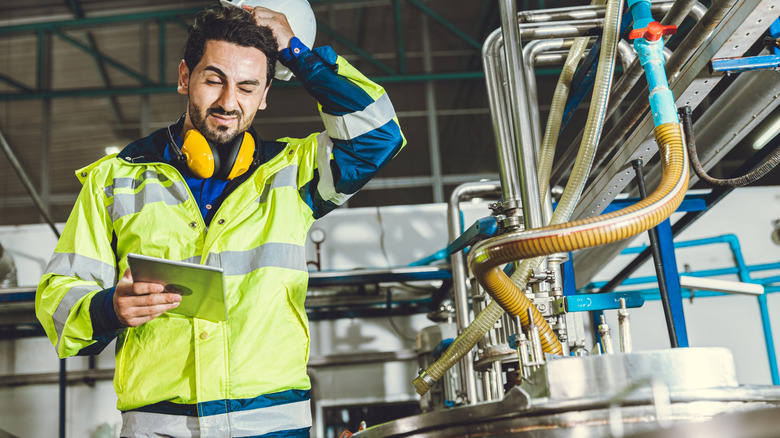 An engineer working in factory stressed about equipment
