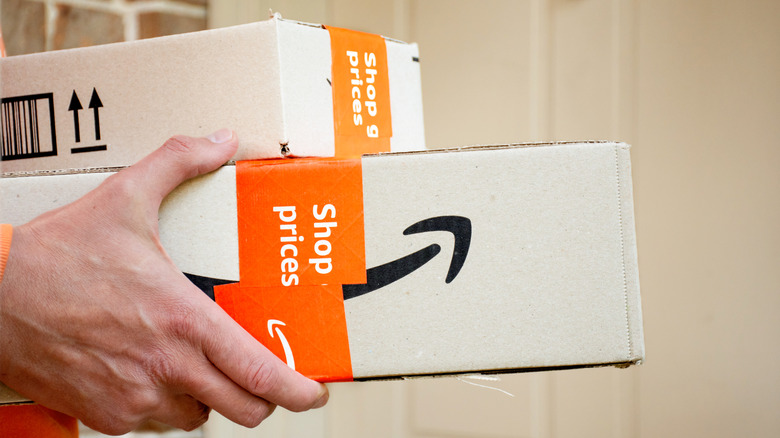 Person holding two Amazon packages