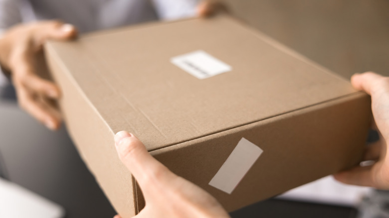 Person handing package to another person