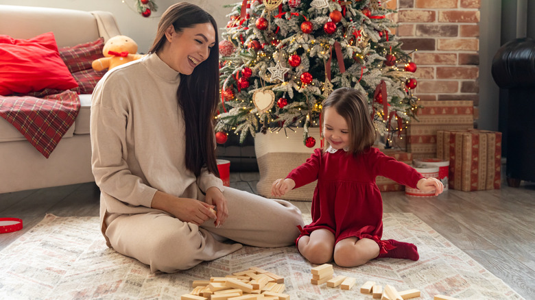 Woman enjoying a preschooler playing with a gift