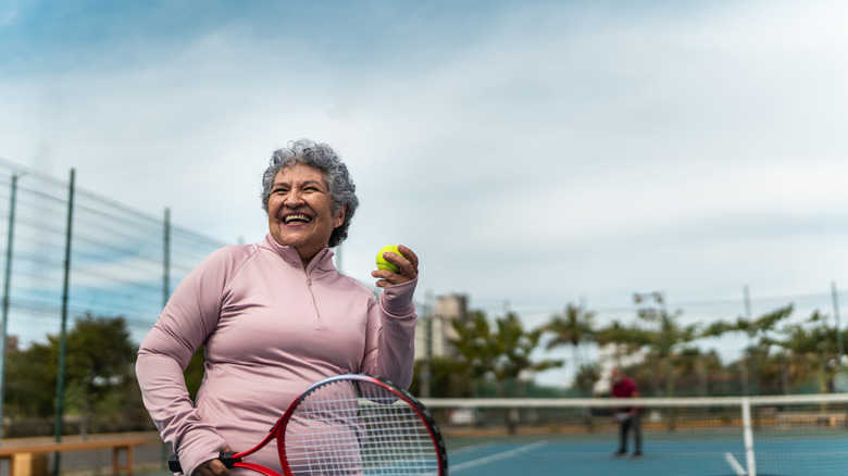 Mature woman playing tennis outdoors