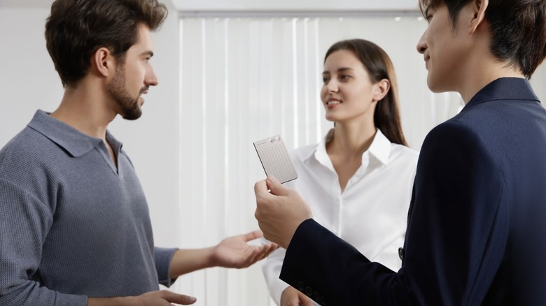 group of people talking with PLAUD.AI device