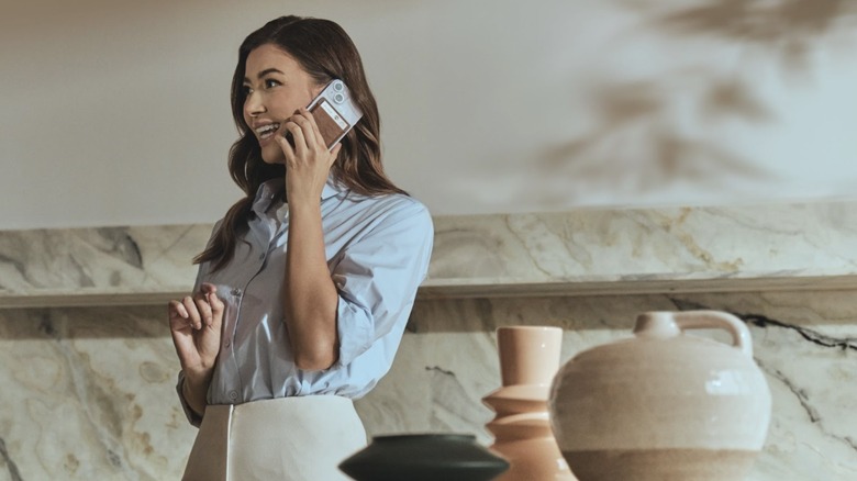 woman talking on phone with PLAUD.AI device