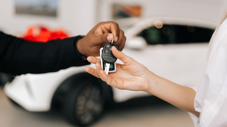 Person handing car keys to another person