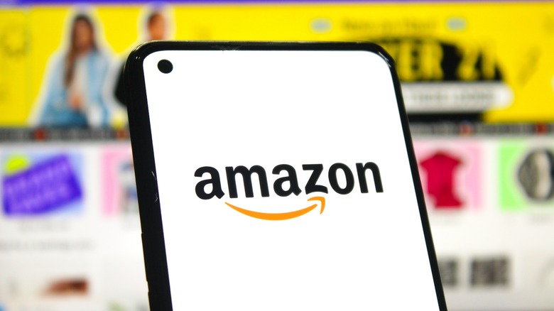 amazon logo on phone and advertisement in background