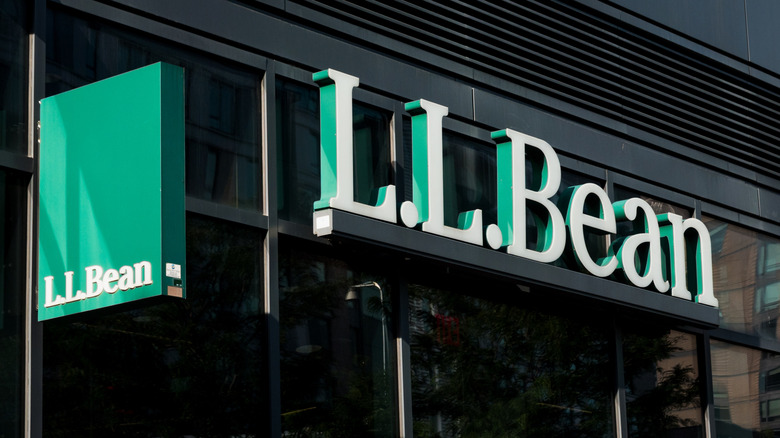 The entrance sign of an L.L. Bean is seen on the facade of a building on a sunny day