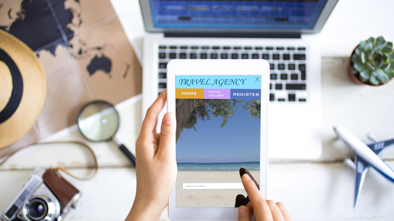 A woman booking a vacation through a travel agency site on her tablet.