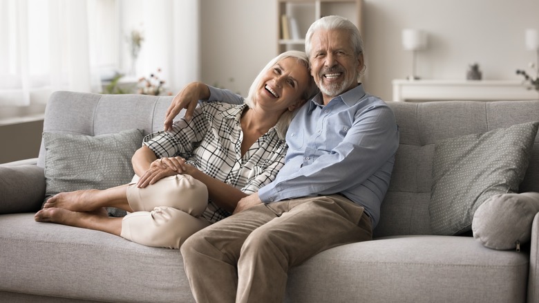 Baby boomer couple relaxing on couch in living room