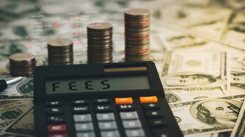 Fees on a calculator in front of money