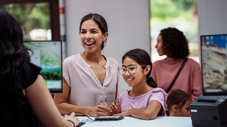 Smiling woman with her child at a bank teller's desk
