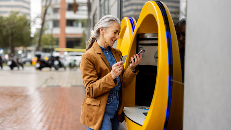 woman using an ATM at her bank