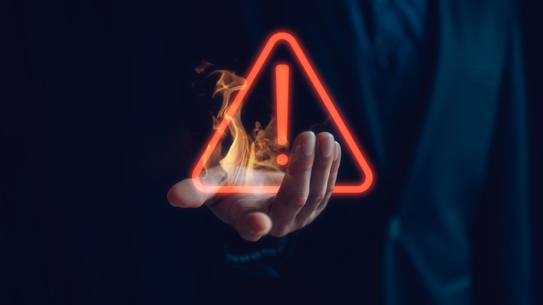 a warning sign in a person's hand