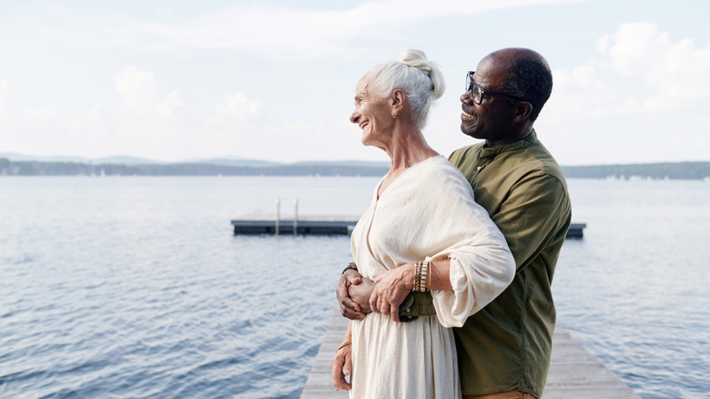 A mature couple on a lake dock.
