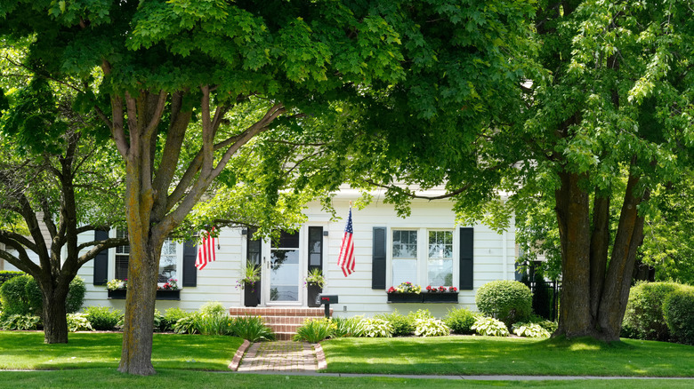 A white home on a tree-lined street in Rogers City, Michigan.