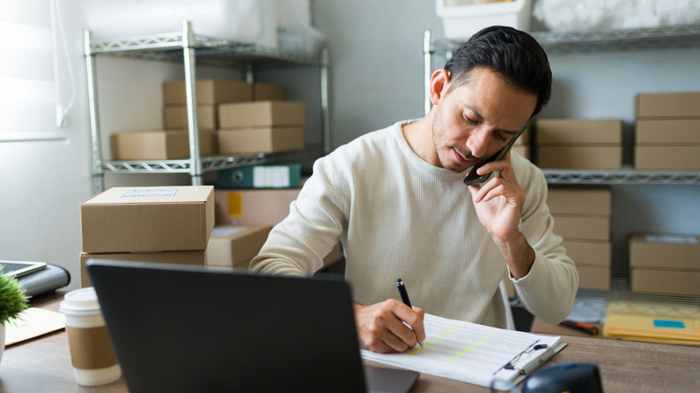 Entrepreneur with laptop on the phone taking an order